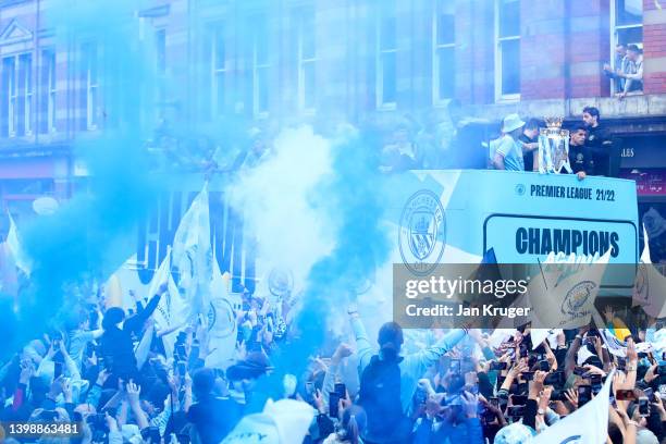 The Manchester City team are seen as the open top bus parades through the city with the Premier League trophy during the Manchester City FC Victory...