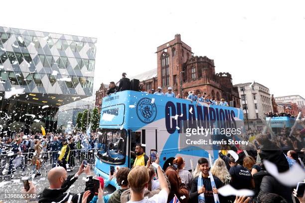 The Manchester City team are seen as the open top bus parades through the city with the Premier League trophy during the Manchester City FC Victory...