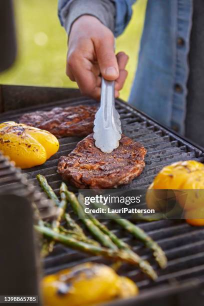 grillen von rib eye steaks auf dem grill - tongs stock-fotos und bilder