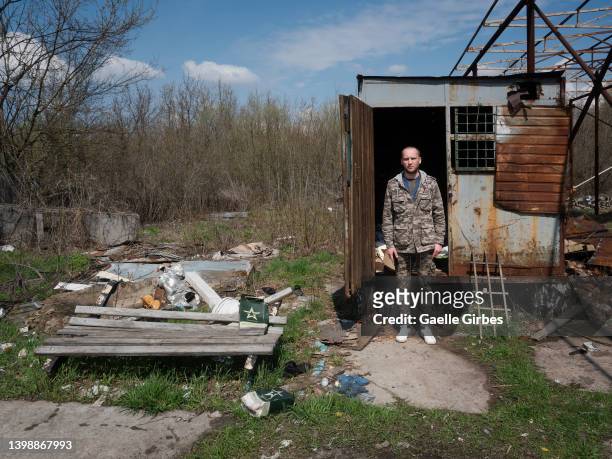 Valera, 32 years old, poses in front of what served as his cell, a metal container in which he was locked up for several days and fed with the...