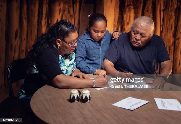 voting by mail - family around a table in their hogan - voting by mail stock pictures, royalty-free photos & images