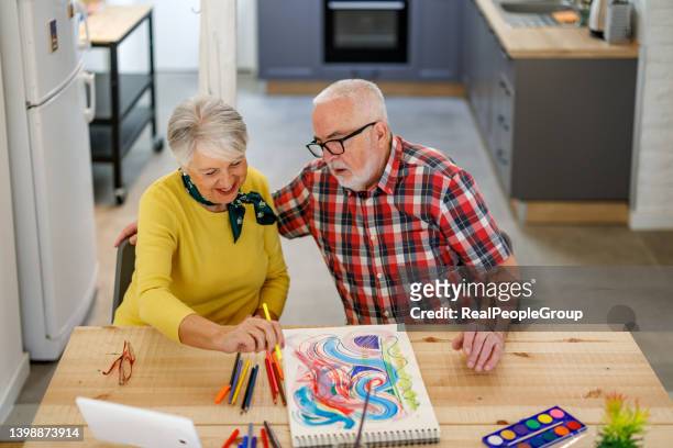 senior couple painting together at home - house for an art lover stock pictures, royalty-free photos & images