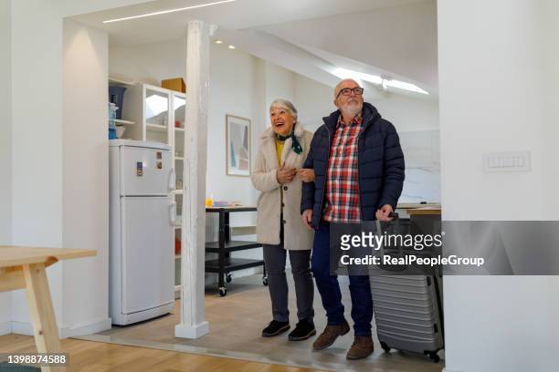 senior couple enters a rented apartment through airbnb - guest room stock pictures, royalty-free photos & images