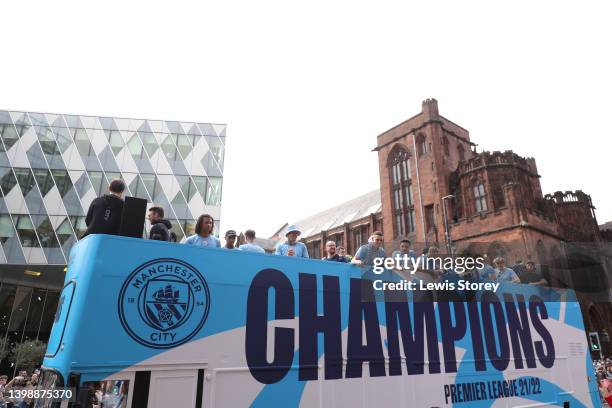 The Manchester City team are seen as the open top bus parades through the city with the Premier League trophy during the Manchester City FC Victory...