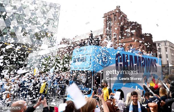 The Manchester City team are seen as the open top bus parades through the city with the Premier League trophy during the Manchester City FC Victory...