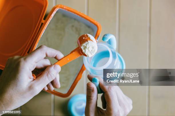 baby formula being scooped into milk bottle - infant formula stock pictures, royalty-free photos & images