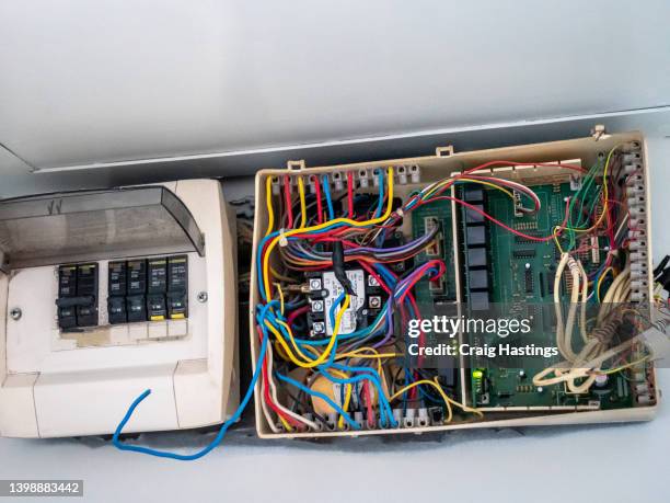 extremely dangerous hotel room wiring and fuse box found in southeast asia whilst on vacation. loose frayed wiring, sparking and causing lighting to flicker as system overloads and causes fuse box to trip. poor health and safety standards. - old motherboard photos et images de collection