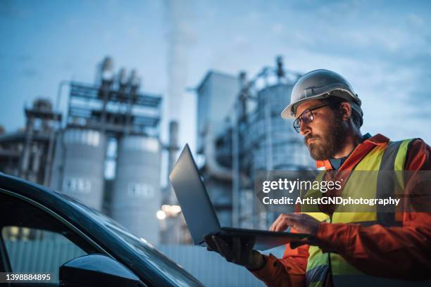 dedicated engineer working until the late hours in the oil and gas industry with laptop. - chemical manufacturing stock pictures, royalty-free photos & images