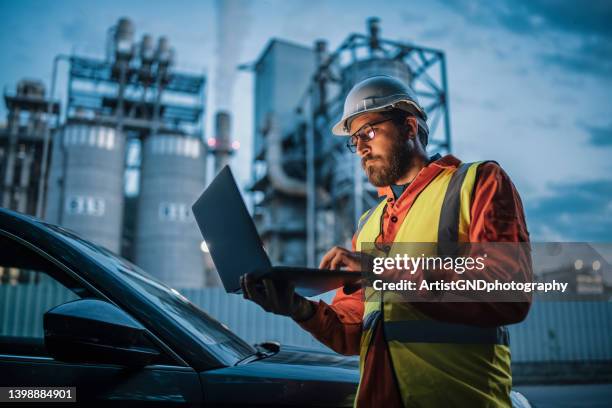 engineer working in the oil and gas industry using laptop. - oil industry stock pictures, royalty-free photos & images