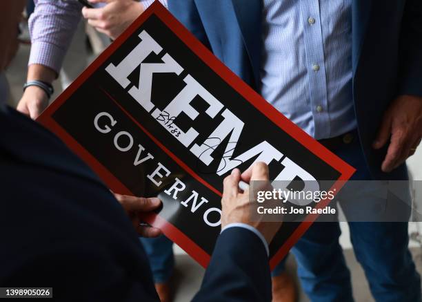 Former U.S. Vice President Mike Pence autographs a sign at a campaign event for Georgia Gov. Brian Kemp at the Cobb County International Airport on...