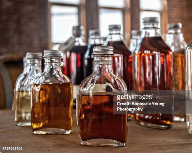 bottles of whiskey at a distillery - likör stock-fotos und bilder