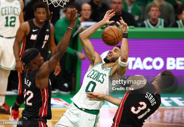 Jayson Tatum of the Boston Celtics looks for a rebound against Jimmy Butler and Max Strus of the Miami Heat during the first quarter in Game Four of...