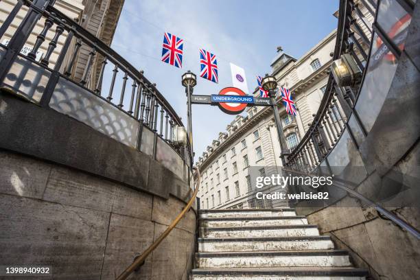 union jack flags above piccadily circus tube station - union jack circle stock pictures, royalty-free photos & images