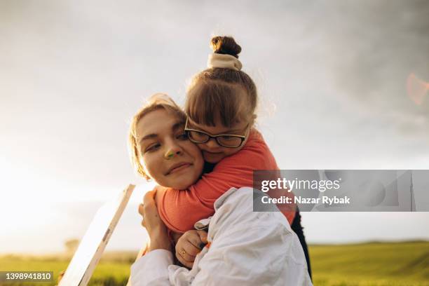 ein downs-syndrom-mädchen umarmt eine frau - daily life in ukraine stock-fotos und bilder