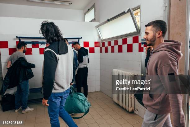 male soccer team entering locker room with casual clothes - mens changing room stock pictures, royalty-free photos & images