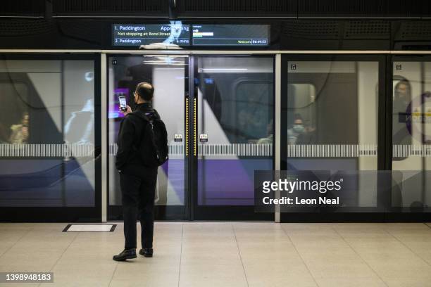 Man waits to board the first scheduled train as the Elizabeth Line opens to the public at Paddington Station on May 24, 2022 in London, England....