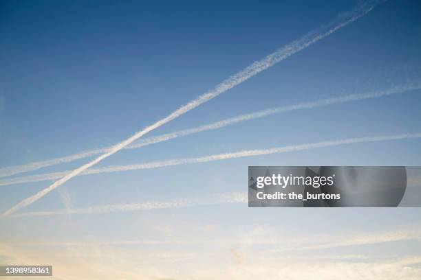 vapor trails in sky during sunset, abstract background - sunset contrail stock pictures, royalty-free photos & images