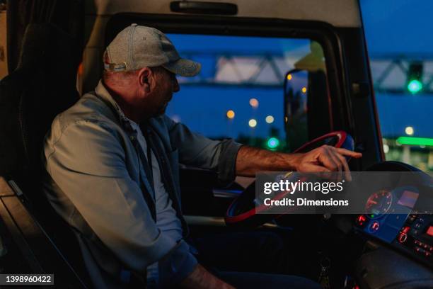 adult man turning the wheel of a truck into the right - truck turning stock pictures, royalty-free photos & images