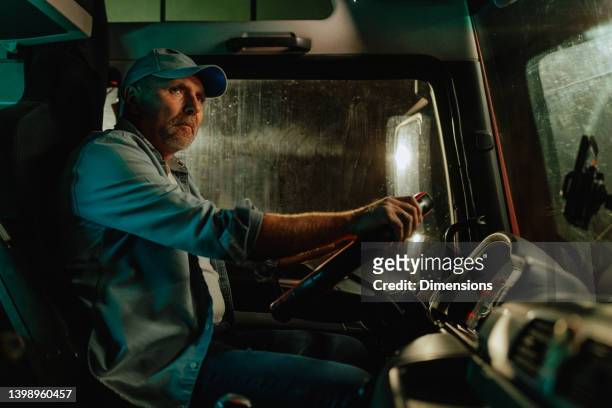 driver in cabin of big modern truck - truck turning stock pictures, royalty-free photos & images