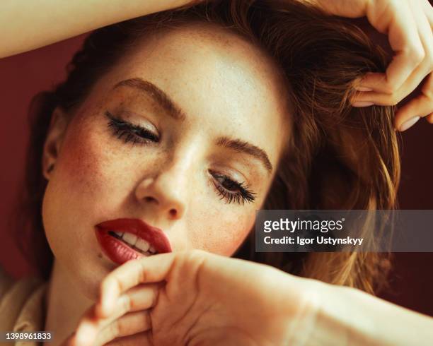 young woman with hands covering head - rougeur photos et images de collection