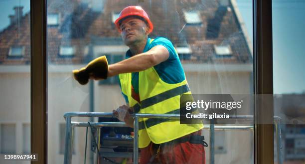 cleaning windows on a residential building. - window cleaner stock pictures, royalty-free photos & images