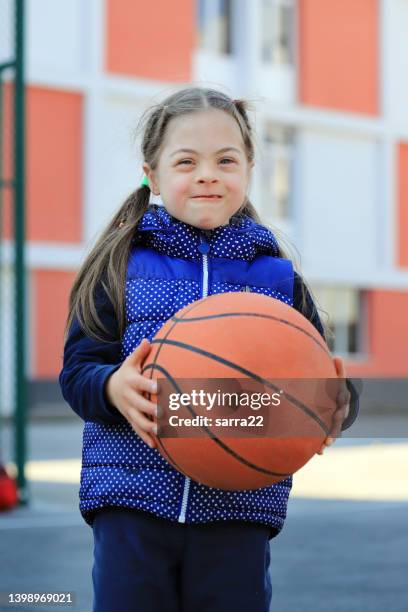 little girl with down syndromе playing basketball - sports activity stockfoto's en -beelden