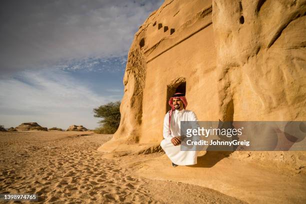 late 20s saudi man exploring mada’in saleh rock-cut tombs - mada'in saleh stock pictures, royalty-free photos & images