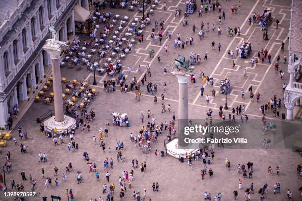 Aerial view, from a helicopter, tourists between the columns of St. Mark and St. Tòdaro, or columns of St. Mark's Square, are two tall columns of...