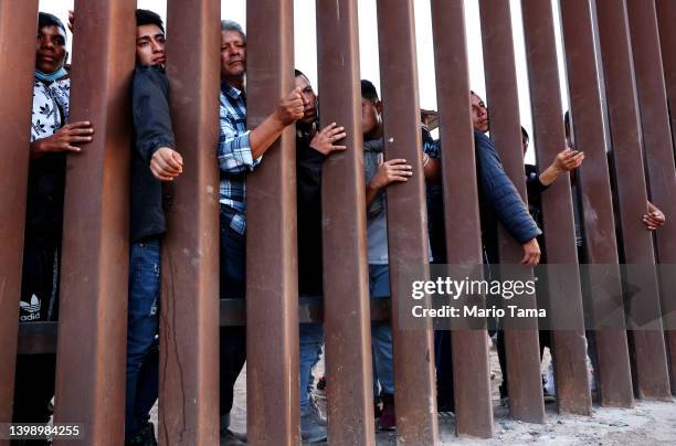 Immigrants wait for soup donated by the Yuma County Abolition group after crossing the border from Mexico on May 23, 2022 in San Luis, Arizona. Some...