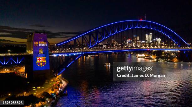 In this aerial view, the Harbour Bridge is lit in the colours of FC Barcelona on May 24, 2022 in Sydney, Australia. History is being made in Sydney...