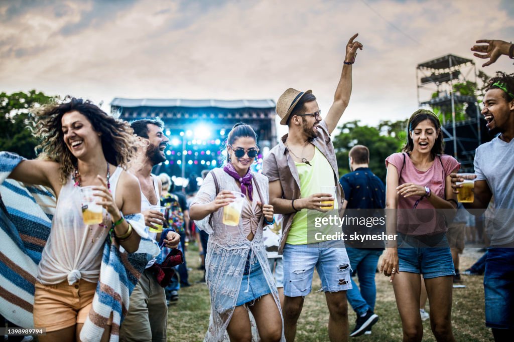 Fröhliche Freunde tanzen auf einem Musikfestival.