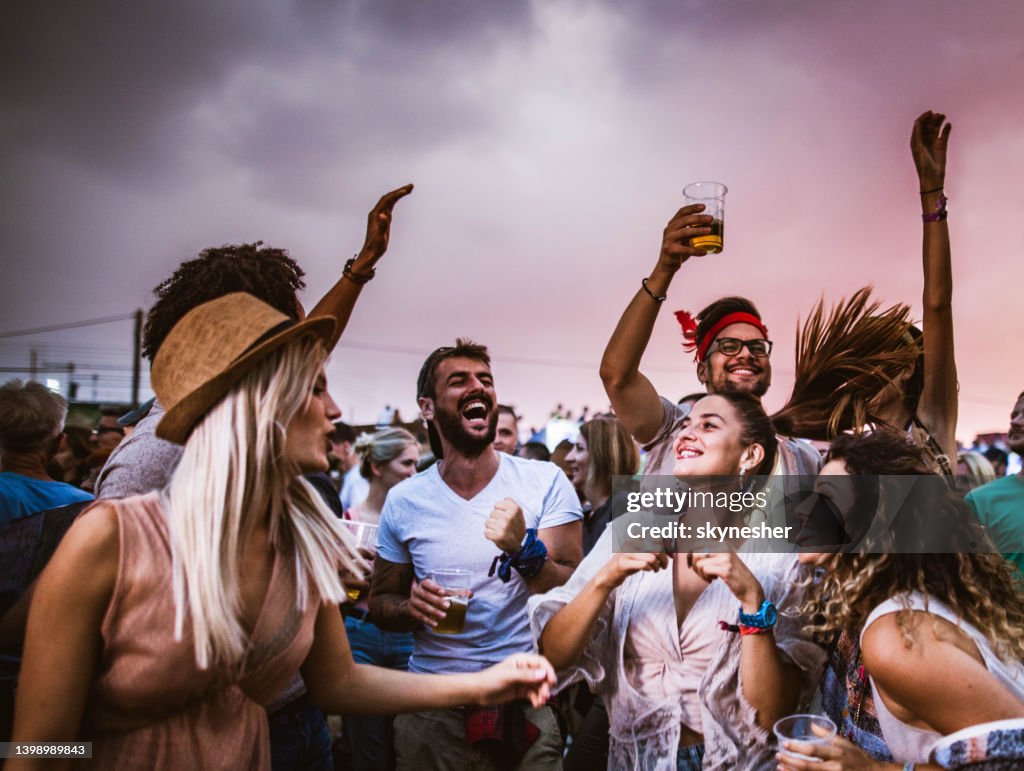 Große Gruppe von fröhlichen Freunden tanzen auf einer Outdoor-Party.