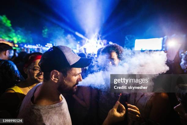 young people smoking marijuana on a music festival. - stick stockfoto's en -beelden