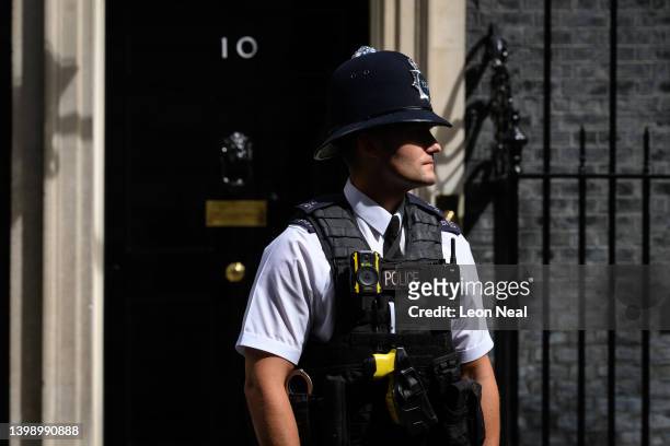 Police officer walks past the front door of number 10, Downing Street on May 24, 2022 in London, England. The Metropolitan Police are facing calls to...
