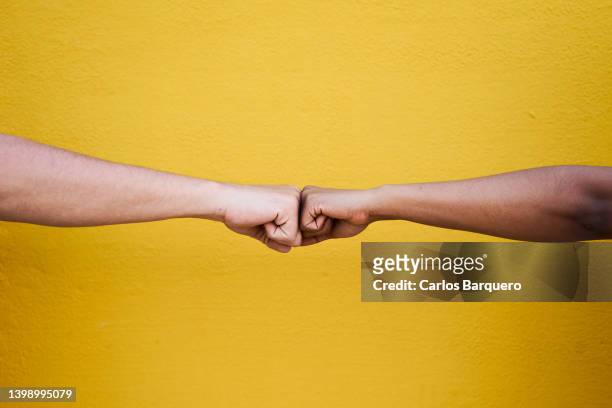 close up of a fist dumb between multiracial friends. - together stock-fotos und bilder