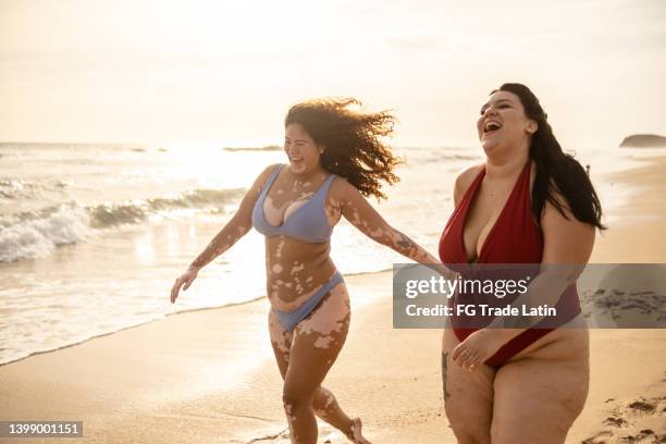 jovens amigas andando na praia - celulite aspecto da epiderme - fotografias e filmes do acervo