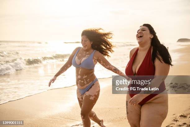 young woman friends walking on the beach - cellulit bildbanksfoton och bilder