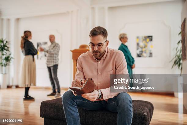 man in art gallery - criticus stock pictures, royalty-free photos & images