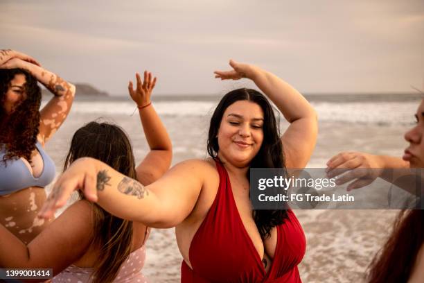 friends having fun dancing in the beach - fat woman dancing stockfoto's en -beelden