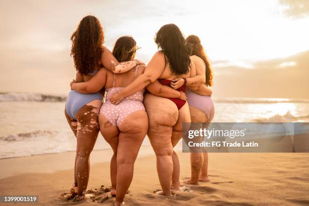 young women embracing on the beach - beautiful fat women stock pictures, royalty-free photos & images