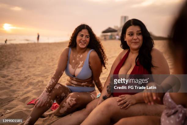 junge frauen unterhalten sich am strand - latin beauty stock-fotos und bilder