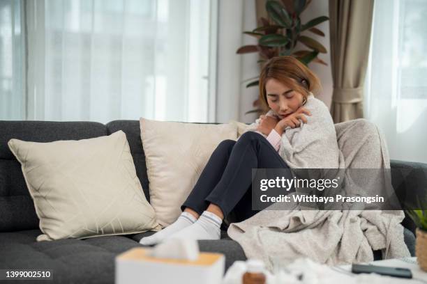 sick woman having flu or cold - indecisive stock-fotos und bilder