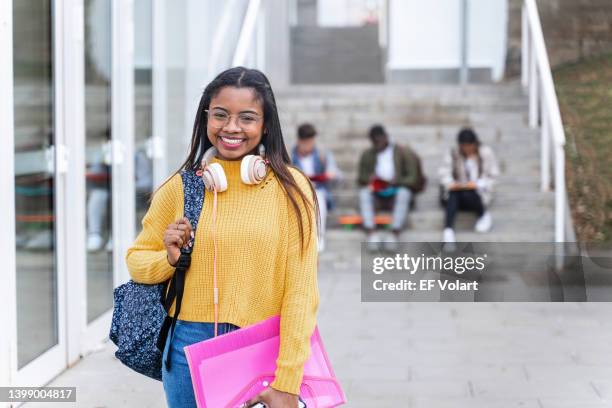 portrait of african american female university student at school campus. smiling latin woman holding a pink folder - secondary school certificate stock pictures, royalty-free photos & images
