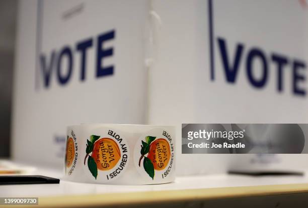 Roll of stickers sit on a table as people vote during the Georgia primary at the Metropolitan Library on May 24, 2022 in Atlanta, Georgia. Election...
