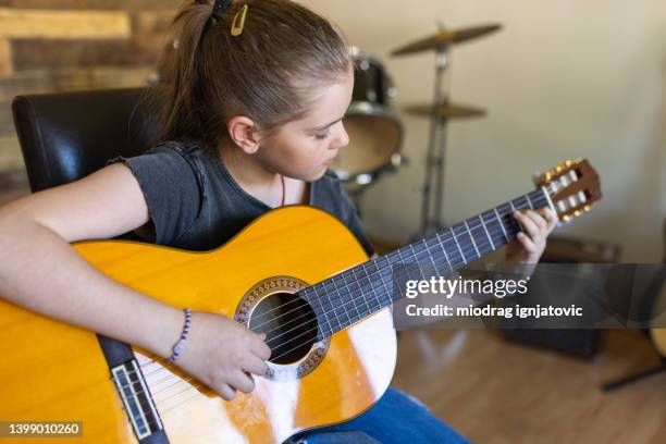 niña tocando la guitarra acústica en la escuela de música - guitar fotografías e imágenes de stock