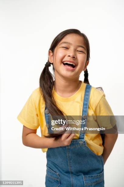waist up studio portrait of an adorable young girl laughing with excitement - very young asian girls ストックフォトと画像