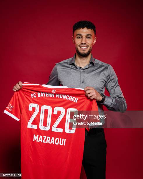 Newly signed player of FC Bayern Muenchen, Noussair Mazraoui, poses with a jersey after his contract signing at Saebener Strasse training ground on...