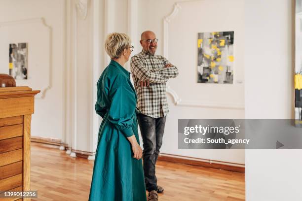 mann und frau in der kunstgalerie - museum besucher stock-fotos und bilder