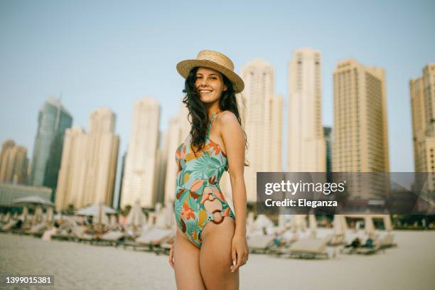 young woman walks towards beautiful beach - eendelig zwempak stockfoto's en -beelden