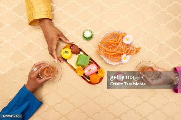 hands eating festive south asian food - europe asian culture stockfoto's en -beelden